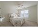 Bright bedroom featuring a ceiling fan and a plush bed with soft, neutral bedding by a window at 403 Tea Olive Ct, Canton, GA 30115