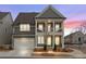 Charming two-story home with a welcoming front porch, gray siding and a two car garage at sunset at 800 Castile Ln, Woodstock, GA 30188