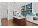 Modern kitchen with white cabinets, a center island, blue backsplash, and stainless steel appliances at 800 Castile Ln, Woodstock, GA 30188