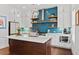Bright kitchen with stainless steel appliances, center island, and vibrant blue tile backsplash at 800 Castile Ln, Woodstock, GA 30188