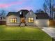 Beautiful exterior featuring a white brick facade, black framed windows, green lawn, and garage at 1774 Vesta Ave, Atlanta, GA 30337