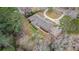 An aerial view of a brick home featuring a large lot with mature trees and a private backyard at 3003 Hanover Se Ln, Conyers, GA 30094