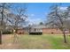 View of a spacious backyard featuring a playset, lush lawn, and mature trees at 3003 Hanover Se Ln, Conyers, GA 30094