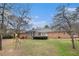 Expansive backyard featuring a well-maintained lawn, mature trees, and a play set at 3003 Hanover Se Ln, Conyers, GA 30094