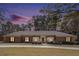 Charming brick home with a well-manicured lawn and mature trees at twilight at 3003 Hanover Se Ln, Conyers, GA 30094