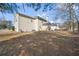 View of the home's backyard showing the spacious area and exterior elevation, with trees surrounding the home at 9630 Carolina Drive, Jonesboro, GA 30238