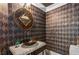 Striking powder room featuring textured wallpaper, unique mirror, and vessel sink on stone counter at 750 Park Ne Ave # 19E, Atlanta, GA 30326
