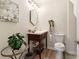 Stylish powder room featuring a vintage vanity, decorative mirror, and floral wall art at 1902 Elm Park Dr, Hampton, GA 30228