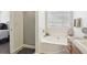 Bright bathroom featuring a soaking tub, separate shower, and neutral color palette at 1902 Elm Park Dr, Hampton, GA 30228
