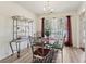 Elegant dining area with a glass-top table, decorative shelving, and natural light from a large window at 1902 Elm Park Dr, Hampton, GA 30228