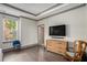 Hardwood floors, a tv and a rocking chair highlight this comfortable bedroom at 589 Broadview Ne Pl, Atlanta, GA 30324