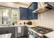 Gourmet kitchen featuring modern appliances, granite countertops, and custom blue cabinetry at 589 Broadview Ne Pl, Atlanta, GA 30324