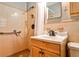 A bathroom with tile walls and light wooden vanity with an accessibility handle at 2446 Sunset Ne Dr, Atlanta, GA 30345
