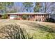 Charming brick home with a well-manicured lawn and mature trees providing shade at 2446 Sunset Ne Dr, Atlanta, GA 30345
