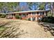 Traditional brick home with a green lawn, complemented by mature trees and a cozy front porch at 2446 Sunset Ne Dr, Atlanta, GA 30345