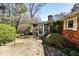 Backyard view of home with brick siding, enclosed porch, and lush landscaping at 2446 Sunset Ne Dr, Atlanta, GA 30345