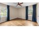 Bright bedroom featuring two windows, wood floors, light walls, and dark blue curtains at 2574 Sugarplum Ne Ct, Atlanta, GA 30345