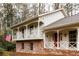 Charming two-story home featuring a brick foundation, neutral siding, a cozy porch, and an American flag at 2574 Sugarplum Ne Ct, Atlanta, GA 30345