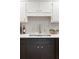 Close-up of a kitchen sink area showcasing stainless steel appliances, white counters, and backsplash at 2574 Sugarplum Ne Ct, Atlanta, GA 30345