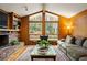 Cozy living room featuring a brick fireplace, large windows, and wood paneled walls at 2574 Sugarplum Ne Ct, Atlanta, GA 30345