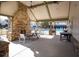 Poolside seating area with a stone fireplace, picnic table and ceiling fans at 4205 Idlewood Dr, Cumming, GA 30040