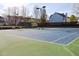 Outdoor tennis court surrounded by a tall, black fence and trees at 4205 Idlewood Dr, Cumming, GA 30040