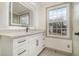 Bright bathroom featuring an illuminated mirror, sleek vanity, and large window at 6645 Doublegate Ln, Rex, GA 30273