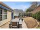 Backyard patio featuring an outdoor dining table, a bench, and manicured landscaping at 6775 Marlow Dr, Cumming, GA 30041