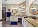 Bathroom featuring granite countertops, dual sinks, updated fixtures, round mirrors, and tiled shower with bench at 6775 Marlow Dr, Cumming, GA 30041