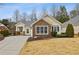 Charming yellow home with stone accents, well-manicured lawn, and paved driveway at 6775 Marlow Dr, Cumming, GA 30041