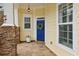 Cozy front porch with stone pillars and a vibrant blue front door with wreath at 6775 Marlow Dr, Cumming, GA 30041