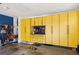 Spacious garage featuring custom yellow storage cabinetry and room for multiple vehicles at 6775 Marlow Dr, Cumming, GA 30041