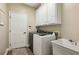 Laundry room with updated appliances, upper cabinets, utility sink and flooring at 6775 Marlow Dr, Cumming, GA 30041