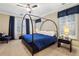 Bedroom featuring canopy bed, plush carpet, neutral walls with wainscoting, and large windows with custom drapes at 6775 Marlow Dr, Cumming, GA 30041