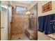 Walk-in shower with mosaic tile accents, rain shower head, built-in bench, glass partition, and window for natural light at 6775 Marlow Dr, Cumming, GA 30041