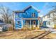 Charming two-story home features a light blue facade, a welcoming front porch, and manicured landscaping at 1092 Wedgewood Nw Dr, Atlanta, GA 30318