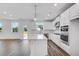Modern kitchen features white cabinets, stainless steel appliances, a large center island, and hardwood floors at 1466 Auburn Glen Rd, Dacula, GA 30019