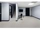 Finished basement featuring neutral carpet, weight bench, stairs, and a storage door at 3321 Spindletop Nw Dr, Kennesaw, GA 30144