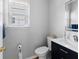 Bathroom with toilet, vanity with sink, mirror, and one window at 3321 Spindletop Nw Dr, Kennesaw, GA 30144