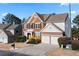 View of a two-story brick home with vinyl siding and attached two-car garage and small front yard at 3321 Spindletop Nw Dr, Kennesaw, GA 30144