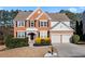 Charming two-story brick home featuring a manicured front yard and attached two-car garage at 3321 Spindletop Nw Dr, Kennesaw, GA 30144