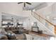 Open-concept living room showcasing staircase, vaulted ceiling, and view into kitchen area at 3321 Spindletop Nw Dr, Kennesaw, GA 30144