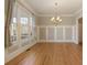 Elegant dining room featuring hardwood floors, large windows with curtains, and modern chandelier at 6755 Creek View Ln, Cumming, GA 30041