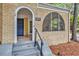 Charming brick home featuring an arched entryway with stairs leading to the front door at 2533 Semmes St, East Point, GA 30344