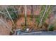 A high-angle aerial view of the wooded backyard featuring a rock garden, mature trees and deck at 1050 Westwell Run, Alpharetta, GA 30022