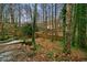 Relaxing backyard with mature trees, privacy fence, and wooden walkway from deck stairs at 1050 Westwell Run, Alpharetta, GA 30022
