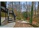 Wooden deck and stairway lead to backyard with rock garden and natural privacy fence at 1050 Westwell Run, Alpharetta, GA 30022