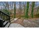 A wooden walkway leads to a peaceful backyard with trees, rocks and privacy fencing at 1050 Westwell Run, Alpharetta, GA 30022