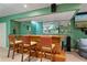 Basement bar area with a wooden bar top, seating, and ample shelving at 1050 Westwell Run, Alpharetta, GA 30022
