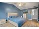 Blue main bedroom offering ample space with a TV, storage, and a modern ceiling fan at 1050 Westwell Run, Alpharetta, GA 30022